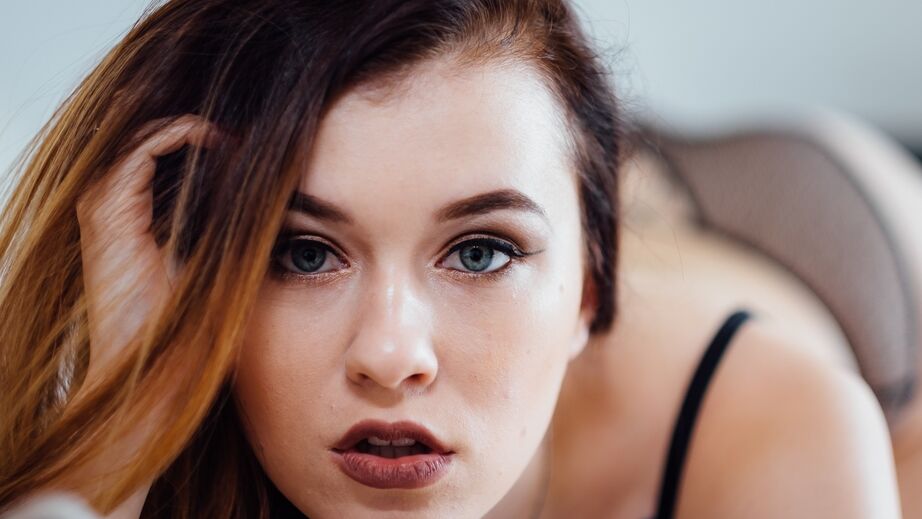 13P Pale redhead model Misha Cross crosses her legs to display her tight pussy