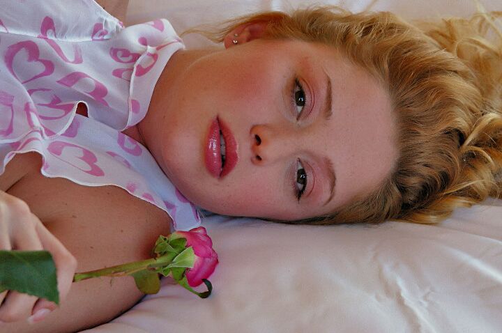 15P La modelo rubia Holly sostiene una rosa solitaria mientras acaricia sus firmes tetas en la cama