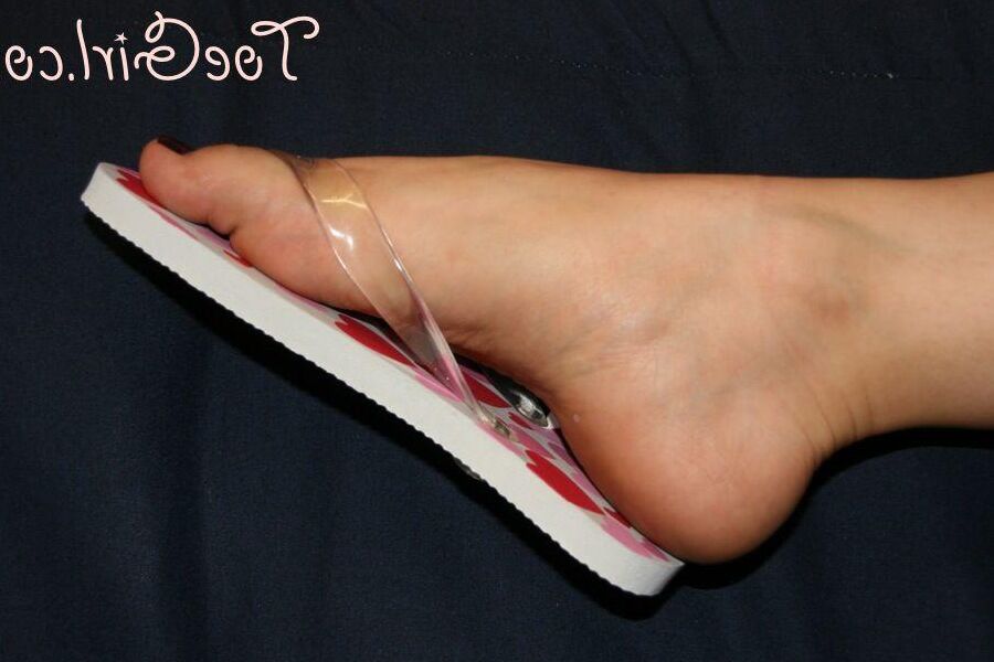 16P Caucasian female wiggles her pretty toes while wearing flip-flops