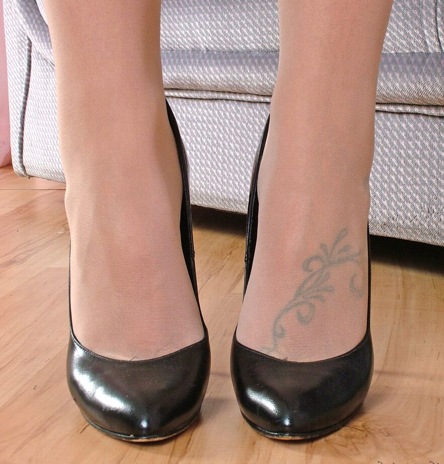 16P Fully clothed lady models black pumps in hose and tight leather skirt