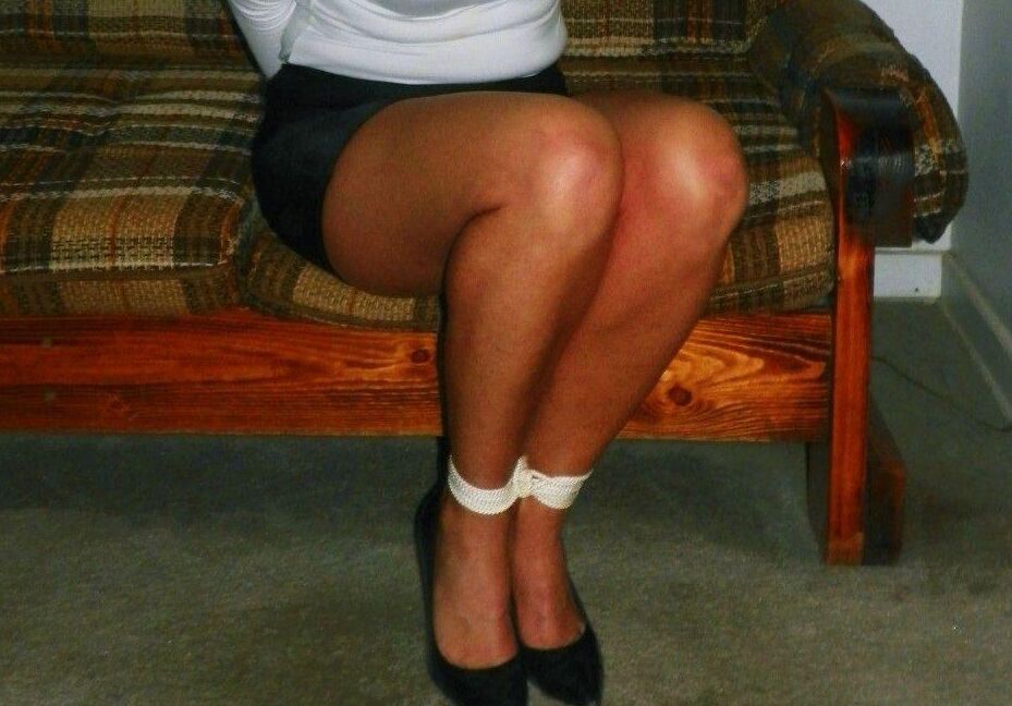 15P Caucasian female is bound at ankles and wrists in a black miniskirt