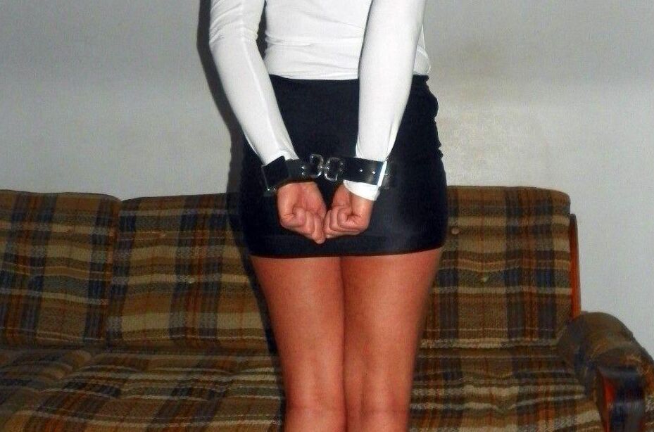 15P Caucasian female is bound at ankles and wrists in a black miniskirt