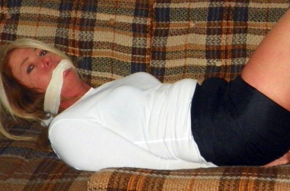15P Caucasian female is bound at ankles and wrists in a black miniskirt