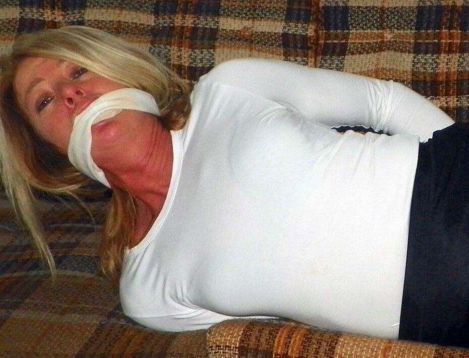 15P Caucasian female is bound at ankles and wrists in a black miniskirt