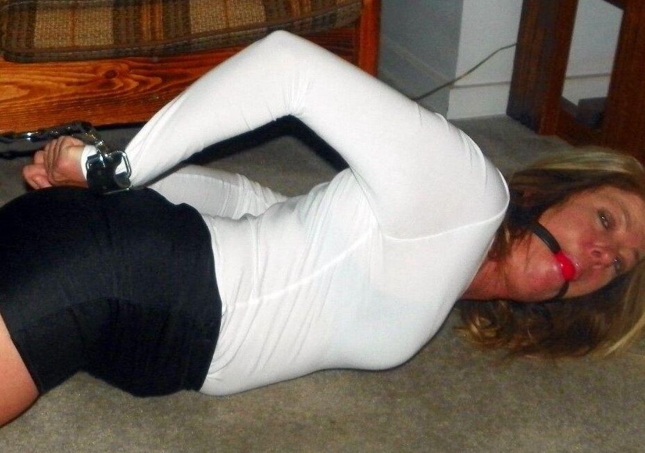 15P Caucasian female is bound at ankles and wrists in a black miniskirt
