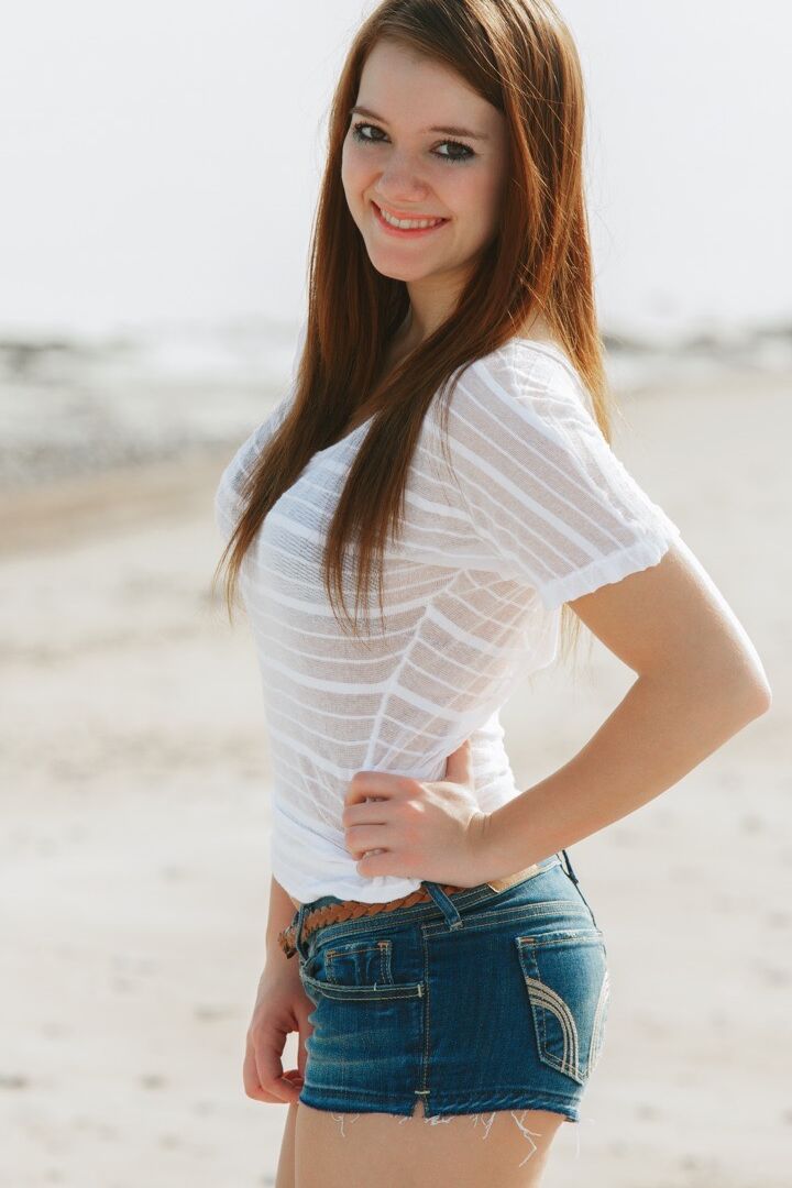 15P La joven de cara fresca Emily French se desnuda completamente en una playa de arena