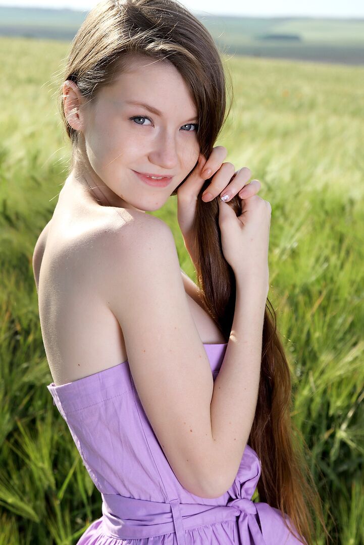 12P Girl-next-door type holds her big tits after getting naked in a farmer's field