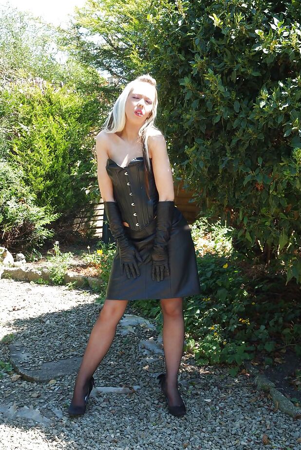 15P Nena rubia sensual con falda de cuero expone su coño recortado en el bosque