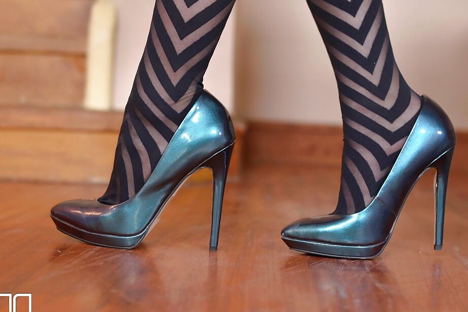 16P La hermosa chica sola Mira Sunset quitándose los tacones altos de sus pies vestidos con medias