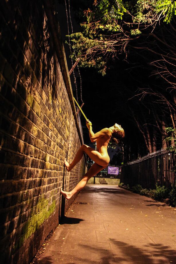 16P Une adolescente nue est attachée à un mur de briques avec une corde jaune la nuit