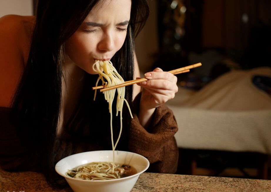 16P La joven morena Chanel Fenn se desnuda totalmente mientras come un plato de fideos