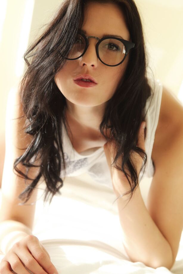 Nika Lace, une jeune femme vêtue de lunettes 18P, enlève sa culotte pour étaler sa chatte rasée d'adolescente.