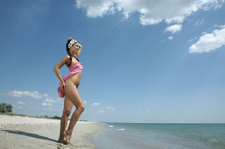 16P Lola B, une adolescente solo, prend des poses nues glamour à la plage.