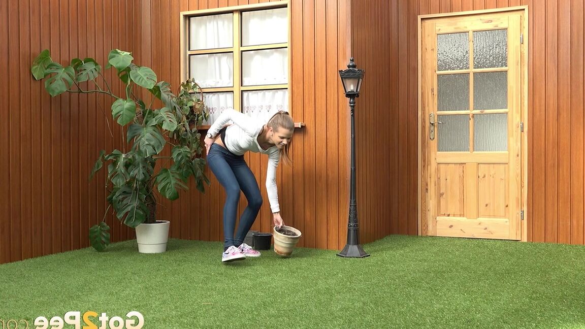 15P Blonde girl Sarah Key pulls down tight jeans to pee in a flower pot