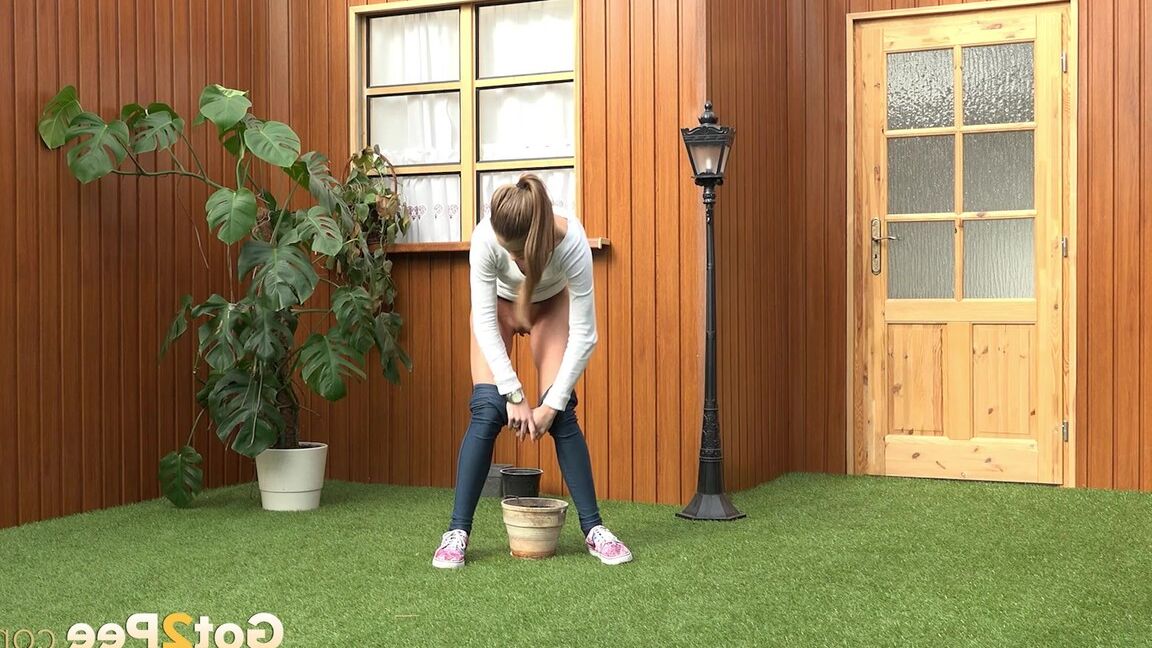 15P Blonde girl Sarah Key pulls down tight jeans to pee in a flower pot