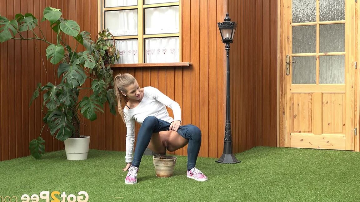 15P Blonde girl Sarah Key pulls down tight jeans to pee in a flower pot