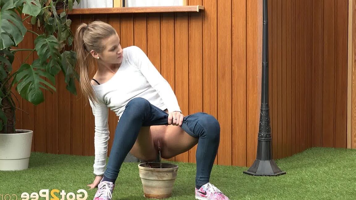 15P Blonde girl Sarah Key pulls down tight jeans to pee in a flower pot