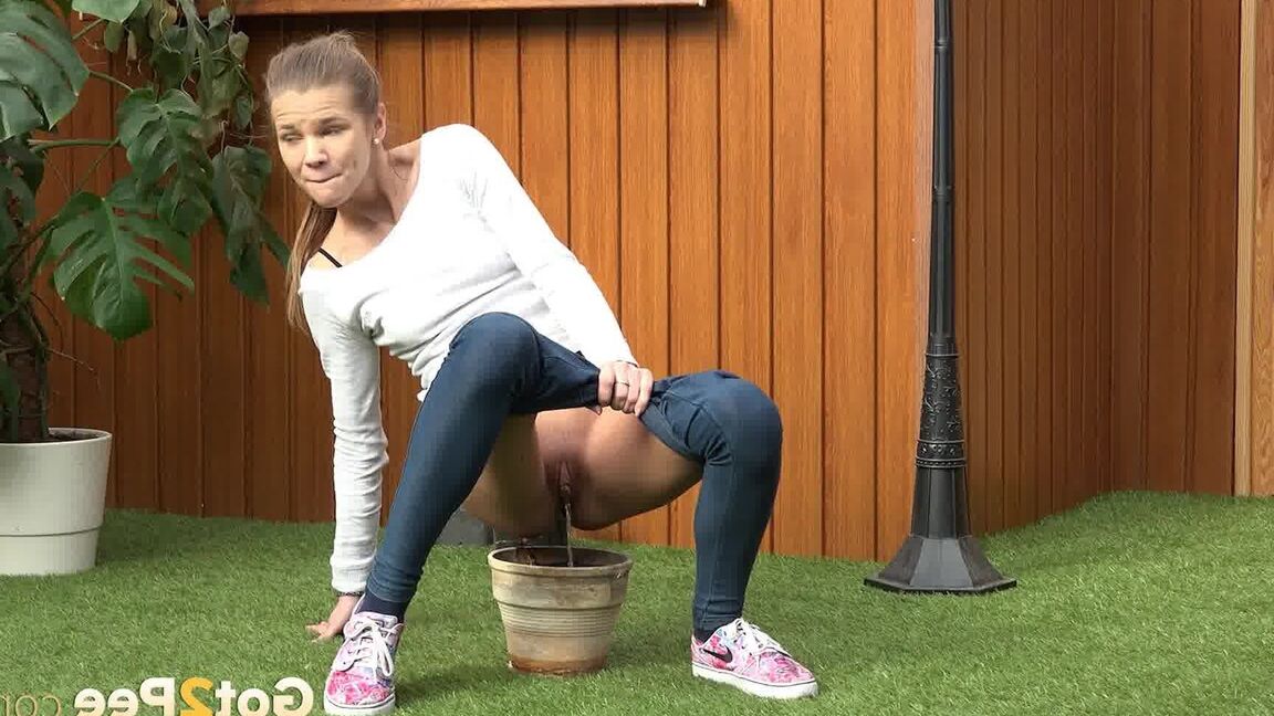15P Blonde girl Sarah Key pulls down tight jeans to pee in a flower pot