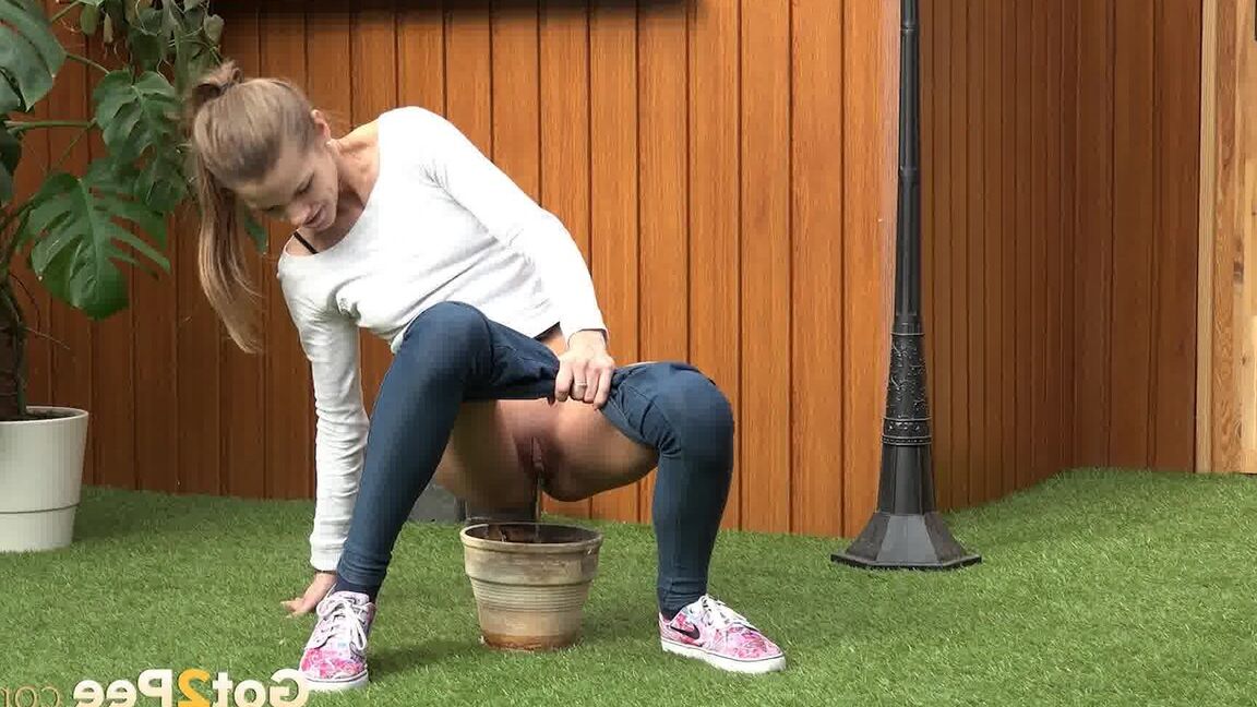 15P Blonde girl Sarah Key pulls down tight jeans to pee in a flower pot