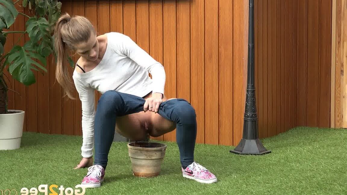 15P Blonde girl Sarah Key pulls down tight jeans to pee in a flower pot