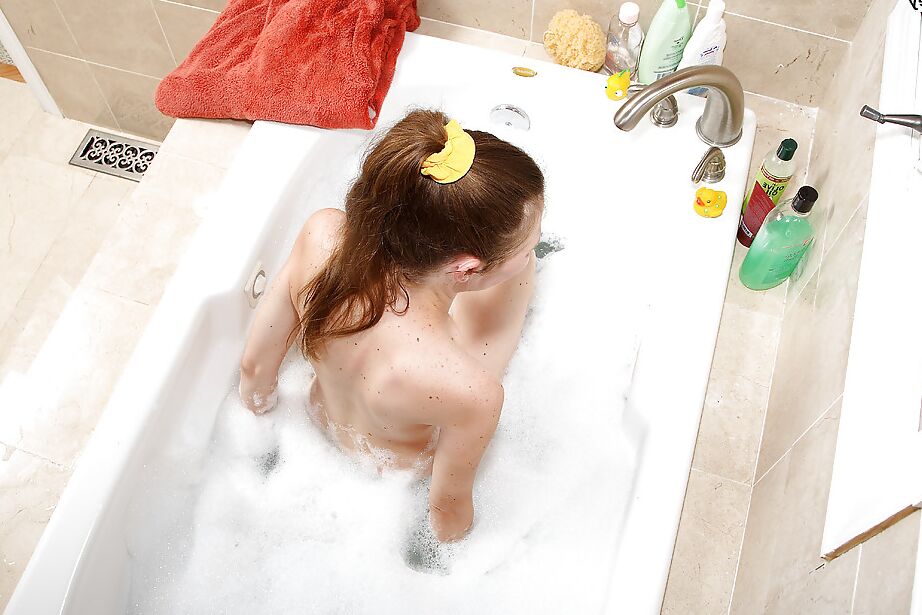 16P Une adolescente maigre doigte son trou rose rasé dans le bain