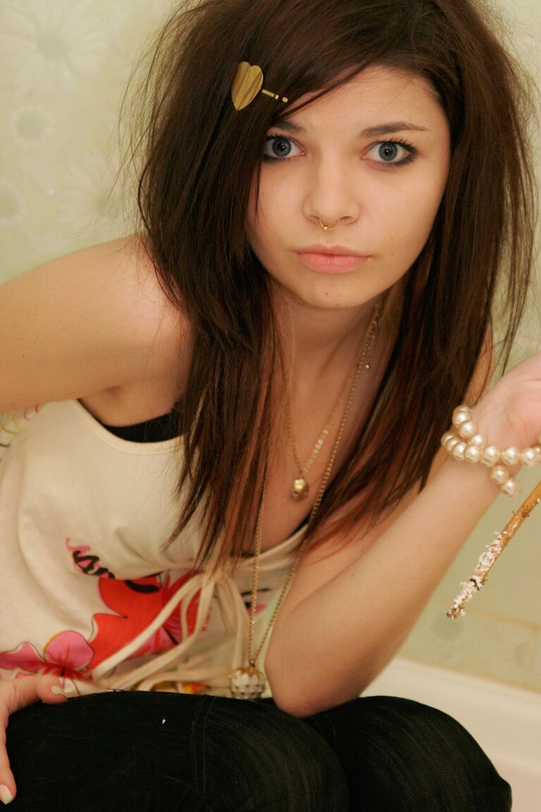 15P Cute girl Kaira 18 holds a stalk of flowers while posing clothed in a bathroom