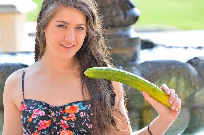 16P Uma linda jovem fica nua por baixo da saia para brincar com um pepino lá fora