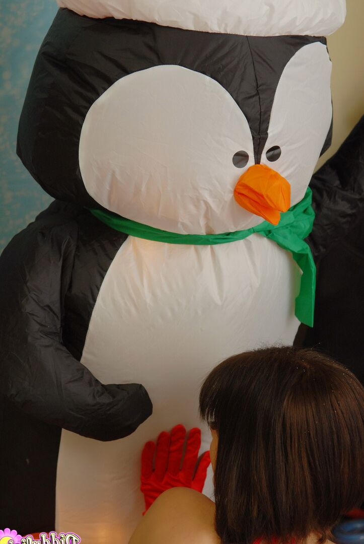 12P La jolie fille Diddylicious embrasse un pingouin gonflable dans une tenue de Noël