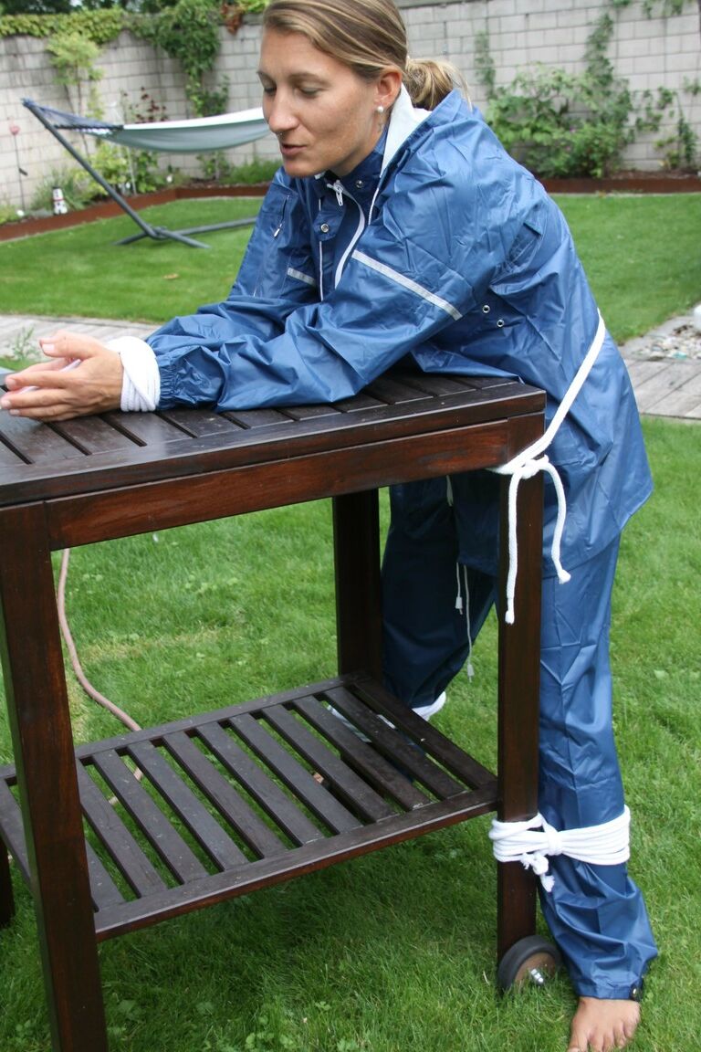 16P Caucasian woman is tied to a table in a yard with panties over her face