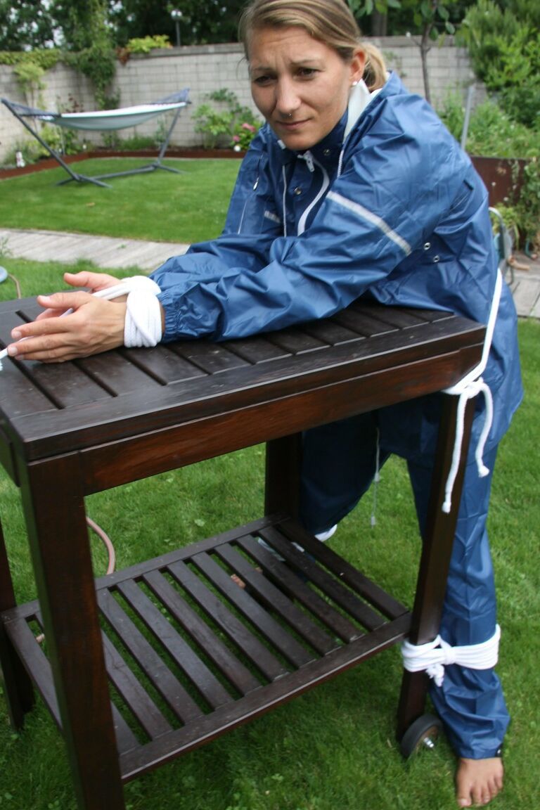 16P Caucasian woman is tied to a table in a yard with panties over her face