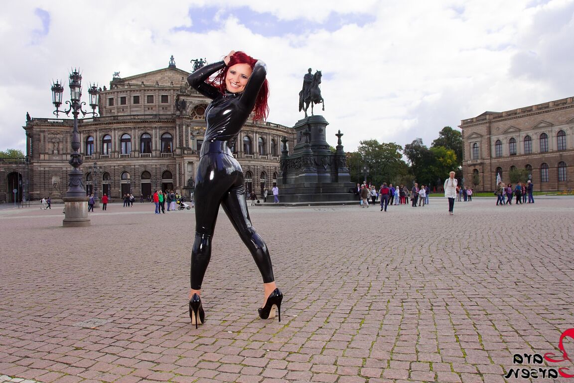 12P Solo model Lara Larsen sports red hair while modelling latex wear in a square