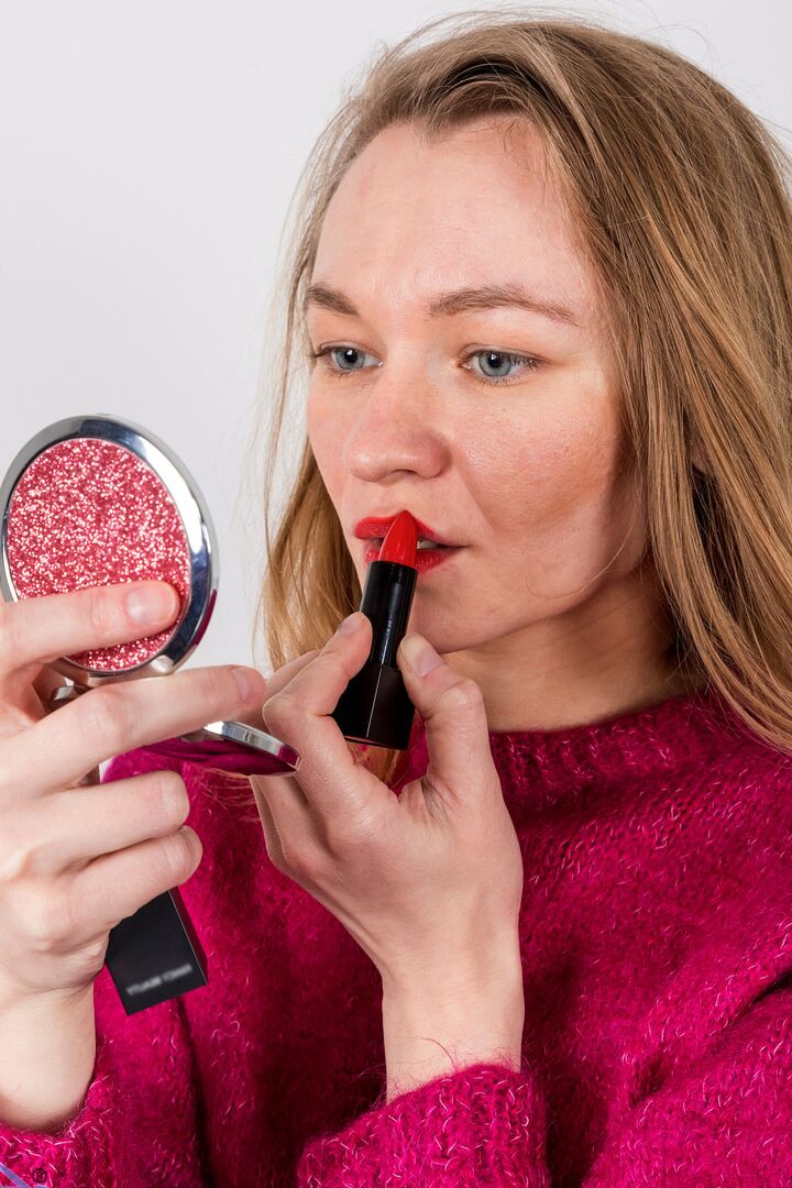 16P Amateur model Kristi does her red lips in a handheld mirror before posing nude