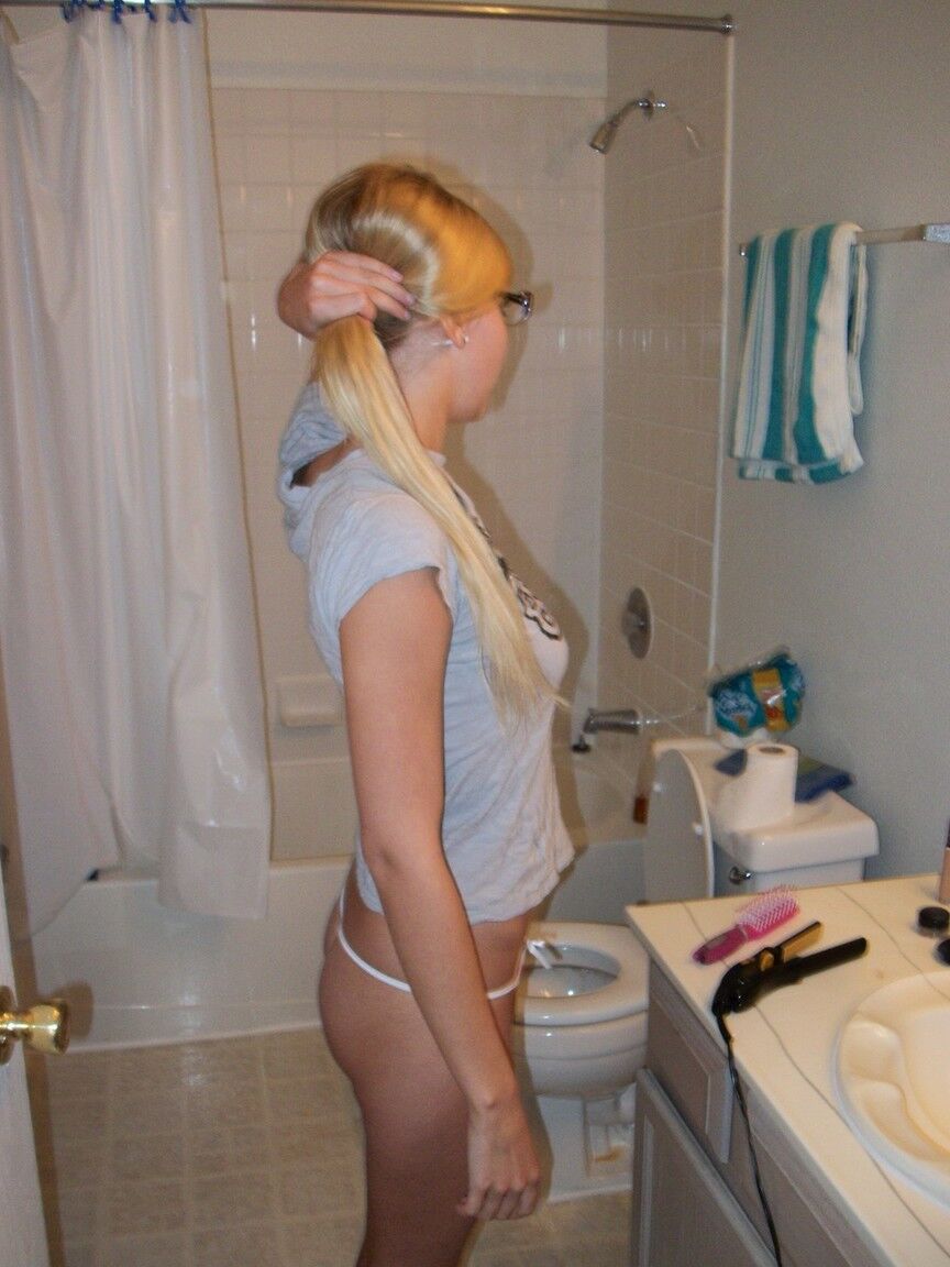 16P Die blonde Amateurin Elle bürstet sich im Badezimmer mit Brille und Tanga die Haare