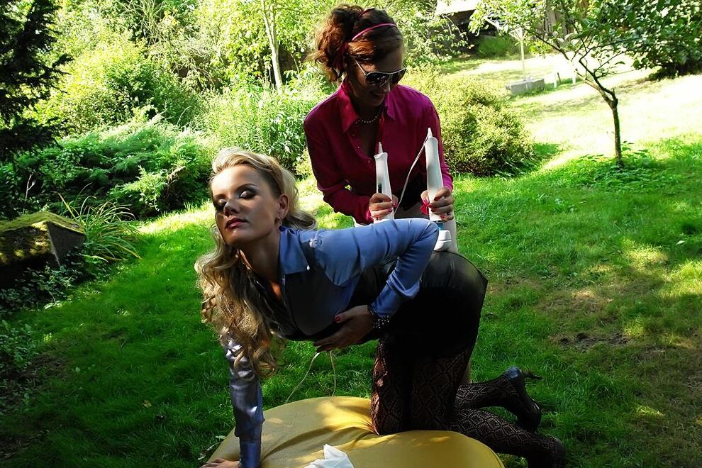 14P Clothed lesbians pleasure each others pussy in a yard with Magic Wands