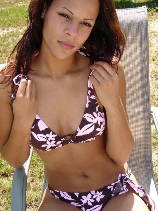 12P La joven amateur Karen modela un bikini con estampado floral en una silla del patio trasero