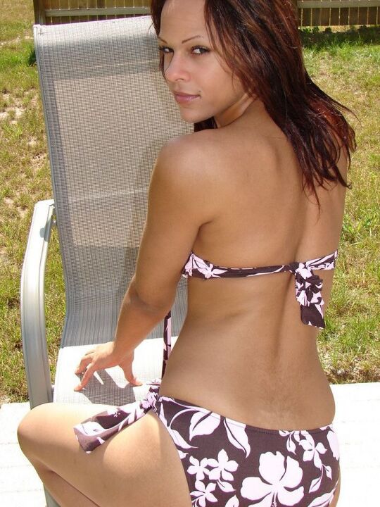 12P La joven amateur Karen modela un bikini con estampado floral en una silla del patio trasero