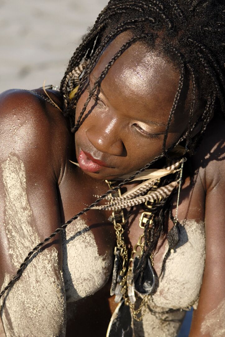 Camille Elizabeth, bodybuilder ébène de 15P, couvre son corps tonique dans le sable de la plage.