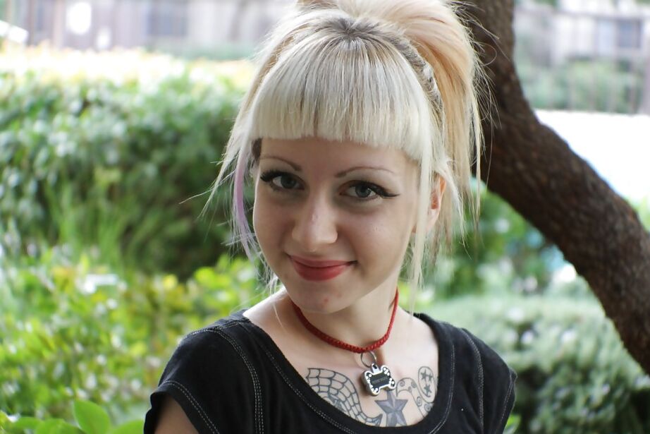 16P La rubia tatuada Symone posa no desnuda al aire libre con una falda plisada