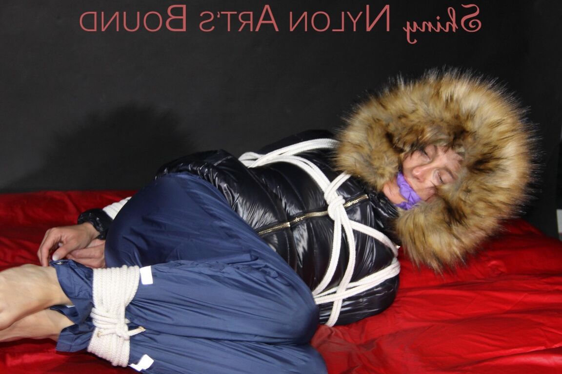 16P Sonja being tied, gagged and hooded on a shiny nylon bed with ropes and a