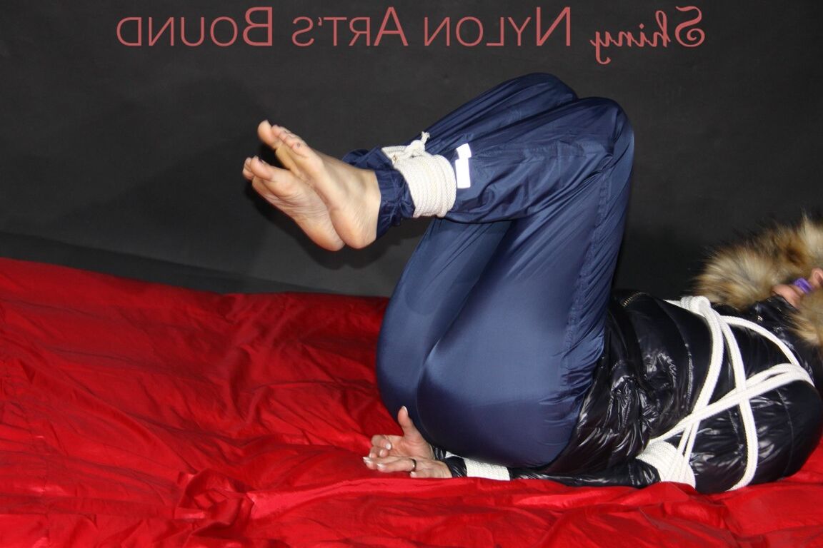 16P Sonja being tied, gagged and hooded on a shiny nylon bed with ropes and a