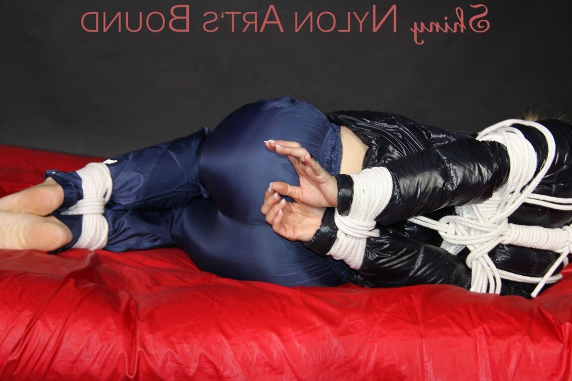 16P Sonja being tied, gagged and hooded on a shiny nylon bed with ropes and a