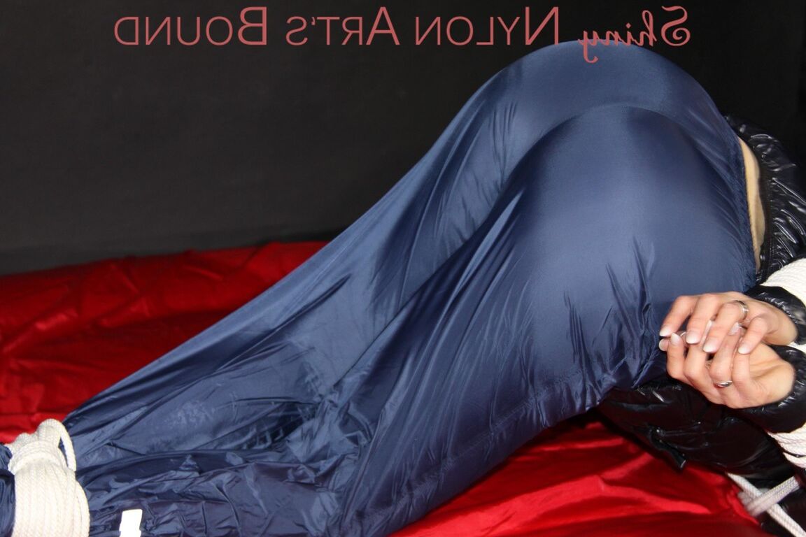 16P Sonja being tied, gagged and hooded on a shiny nylon bed with ropes and a