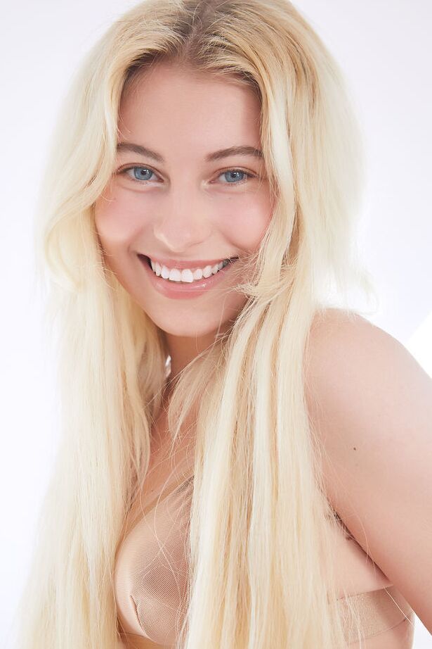 18P La jeune blonde Lilly Bella tient son visage tout en montrant sa fente serrée