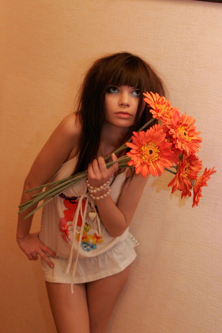 15P La encantadora adolescente Kaira 18 sostiene un ramo de flores durante una sesión sin desnudos