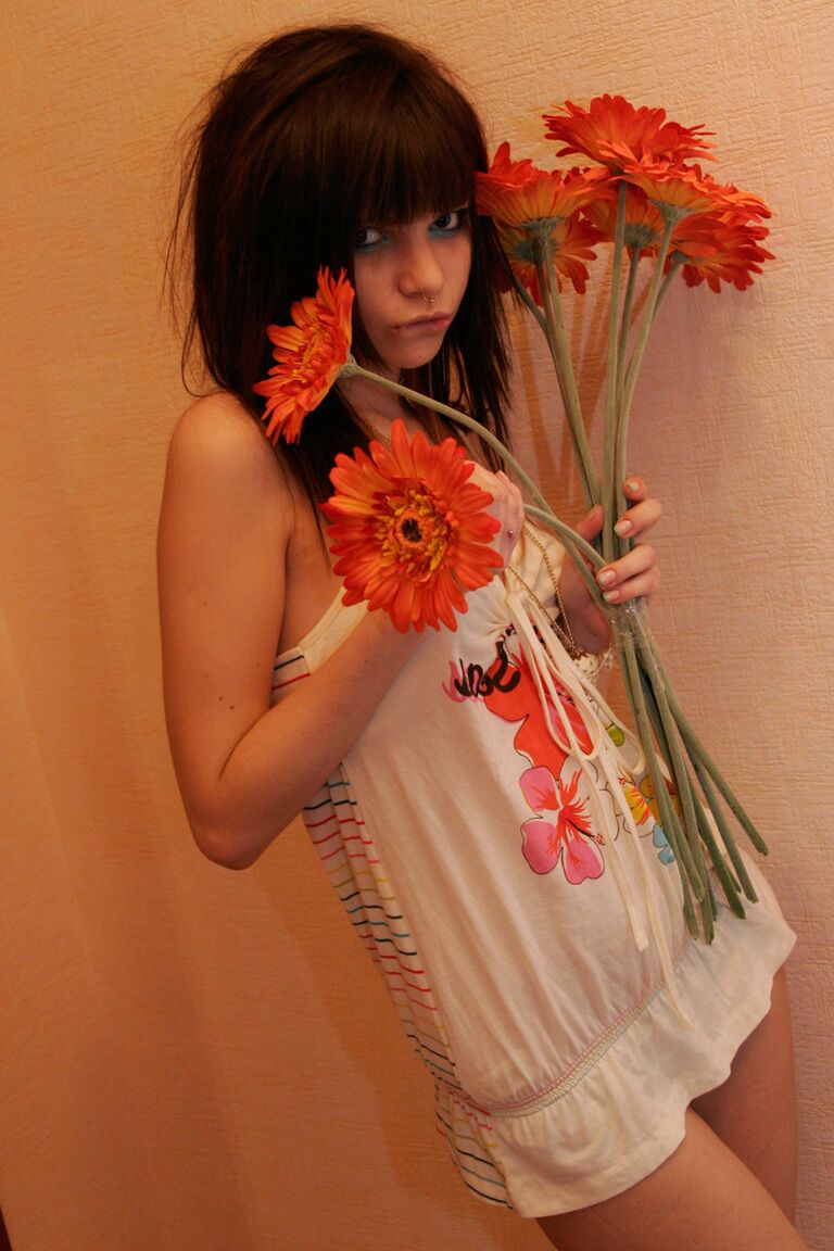15P La encantadora adolescente Kaira 18 sostiene un ramo de flores durante una sesión sin desnudos
