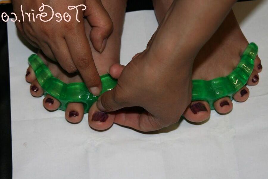 16P Caucasian girl dons toe spreaders before painting her toenails