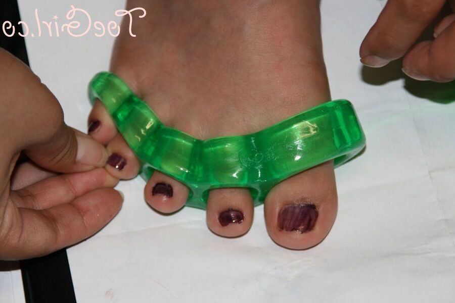 16P Caucasian girl dons toe spreaders before painting her toenails