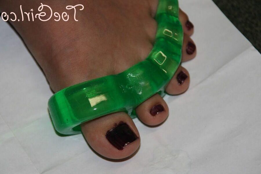 16P Caucasian girl dons toe spreaders before painting her toenails