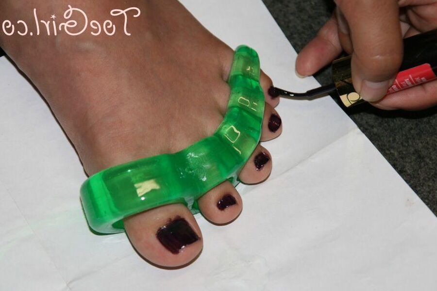 16P Caucasian girl dons toe spreaders before painting her toenails