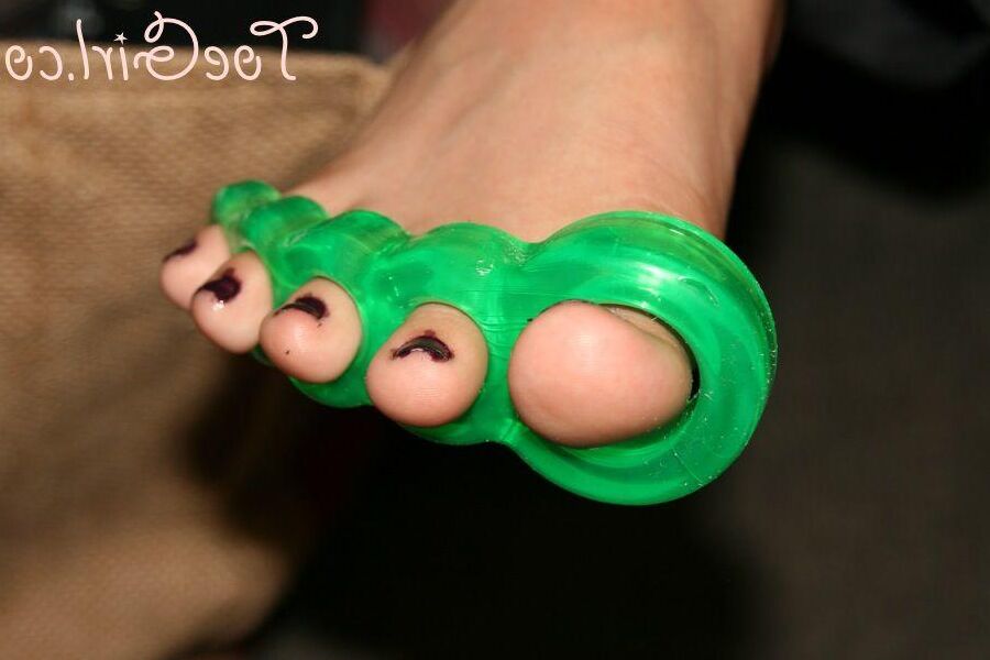 16P Caucasian girl dons toe spreaders before painting her toenails